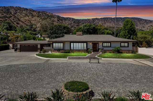a view of a house with backyard and sitting area