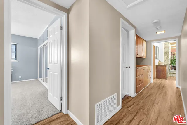 a view of a hallway with wooden floor and staircase