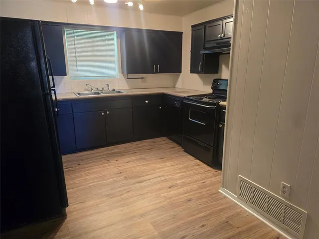 a kitchen with a sink and a refrigerator