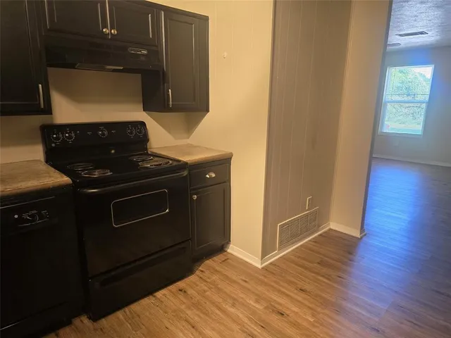 a kitchen with wooden floors and a stove