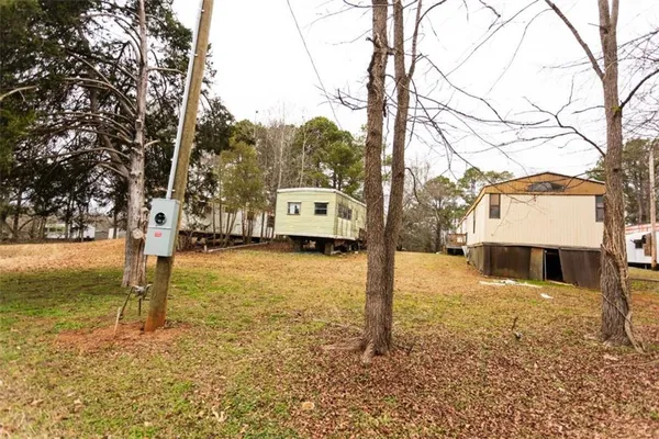 a view of a large white house with a large tree with a yard