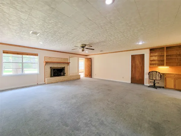 a view of empty room with a fireplace and window