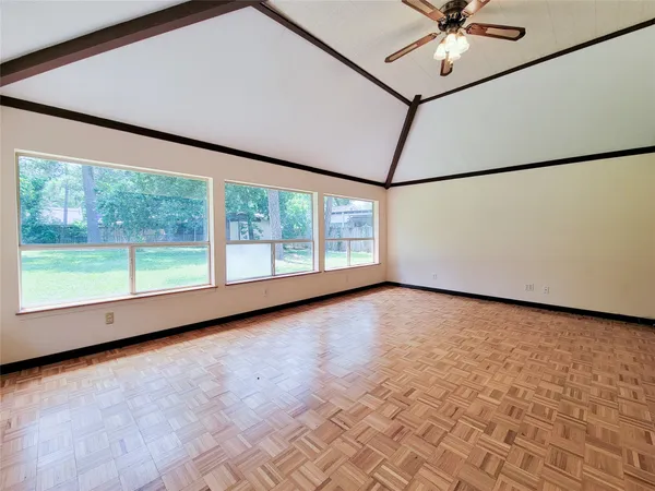 an empty room with wooden floor and windows
