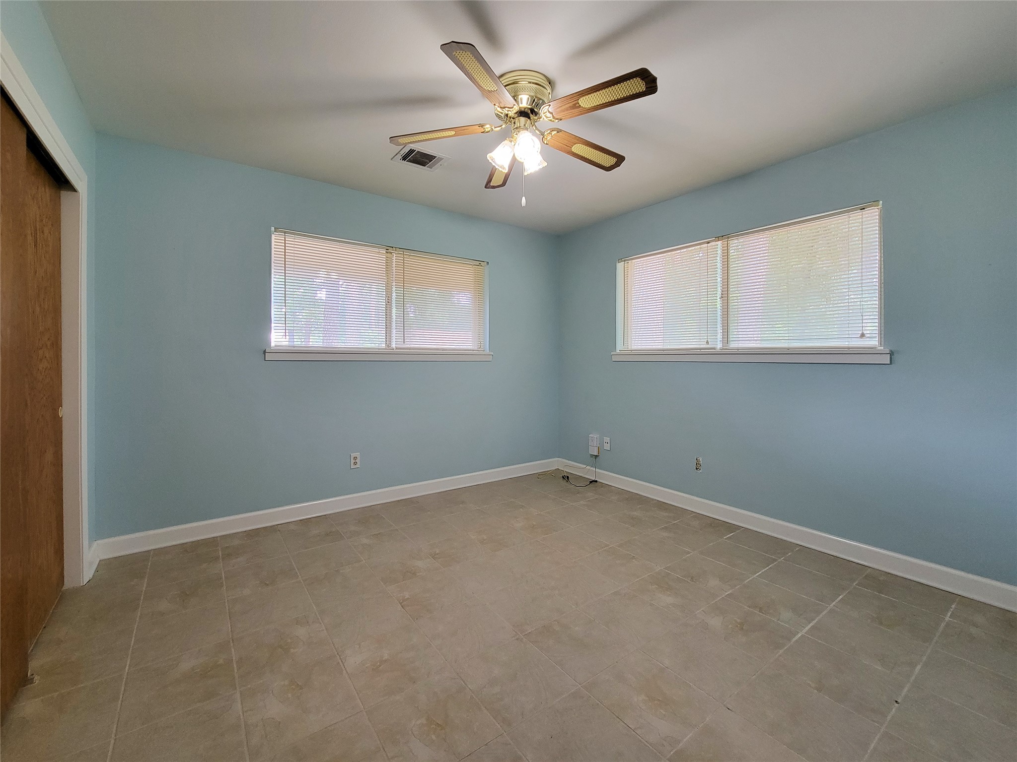 12119 Beverly Drive Houston, TX 77065 - Photo 21 of 32 an empty room with windows and fan