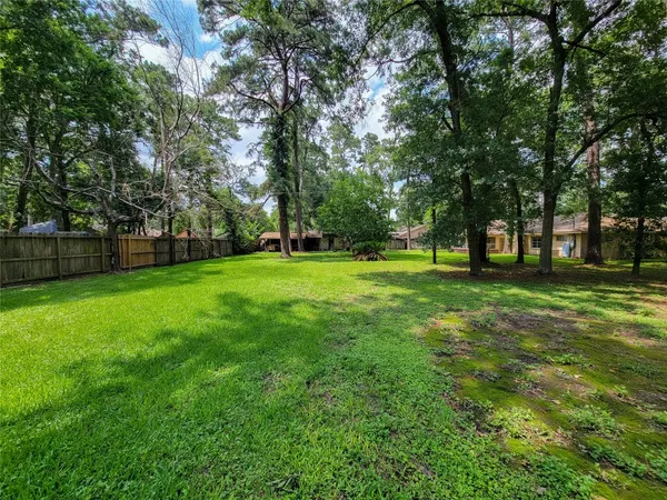a view of a house with a big yard and large trees