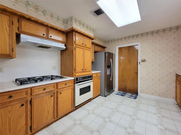 a kitchen with stainless steel appliances granite countertop a stove and a refrigerator