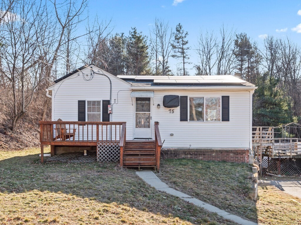 a view of a house with a yard and trees in the background