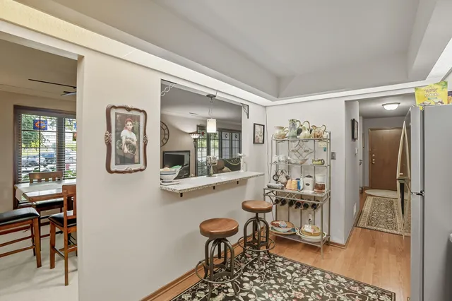 a room with stainless steel appliances a dining table and chairs