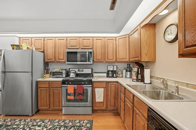 a kitchen with stainless steel appliances granite countertop a refrigerator a stove a sink and a microwave