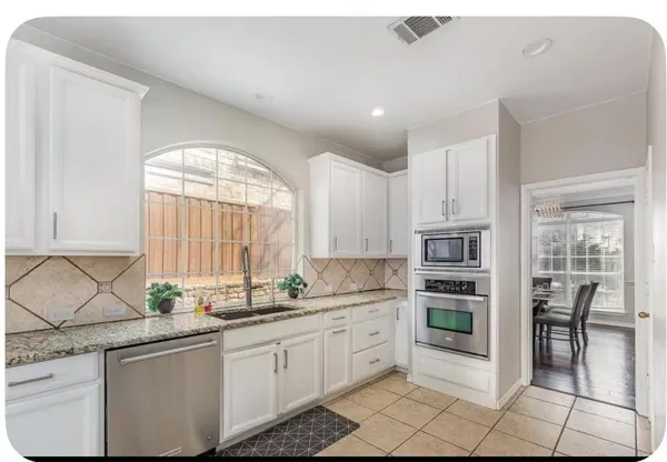 a kitchen with a sink window and cabinets