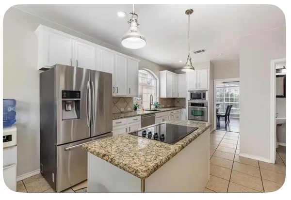 a kitchen with stainless steel appliances granite countertop a sink refrigerator and cabinets