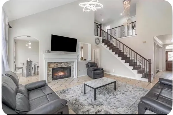 a living room with furniture a flat screen tv and a fireplace