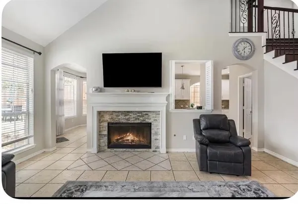 a living room with furniture a flat screen tv and a fireplace