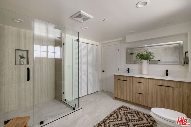 a spacious bathroom with a double vanity sink a large mirror a shower and bathtub