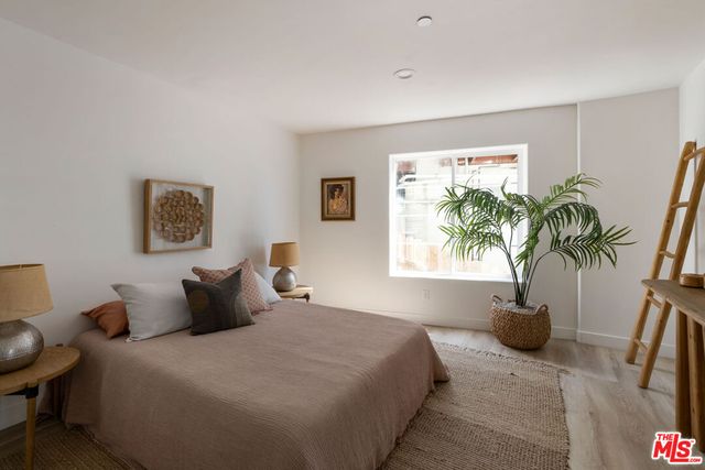 a bedroom with a large bed and a potted plant