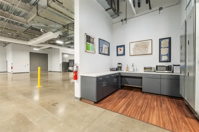 a kitchen with stainless steel appliances kitchen island granite countertop a refrigerator and a sink