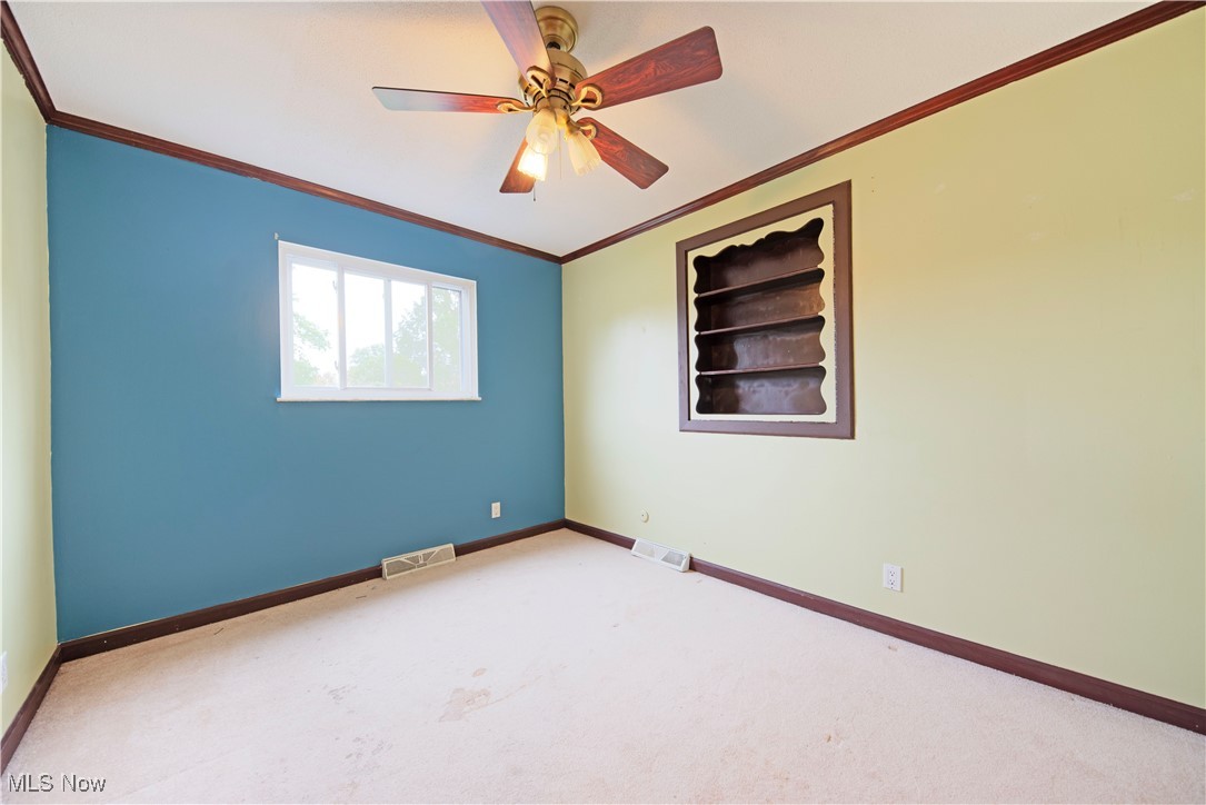 2501 East Pleasant Valley Road Independence, OH 44131 - Photo 22 of 29 Carpeted bedroom with built in shelves, ornamental molding, and ceiling fan