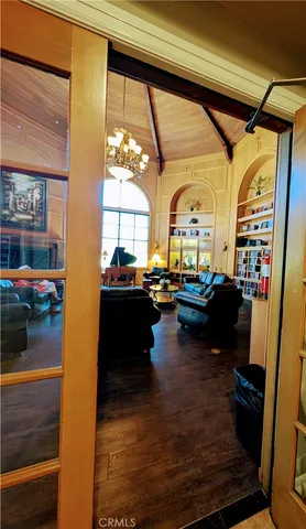 a living room with couches bookshelf and a stove