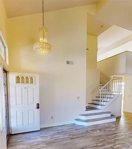 a view of an entryway with wooden floor and a chandelier
