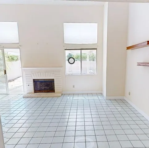 a view of an empty room with window and fire place