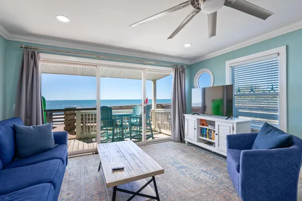 a living room with furniture a flat screen tv and a large window