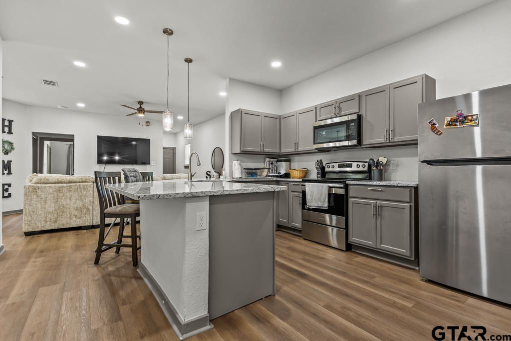 1919 West Jackson Street Tyler, TX 75701 - Photo 14 of 35 a kitchen with kitchen island granite countertop a sink a counter top space stainless steel appliances and cabinets