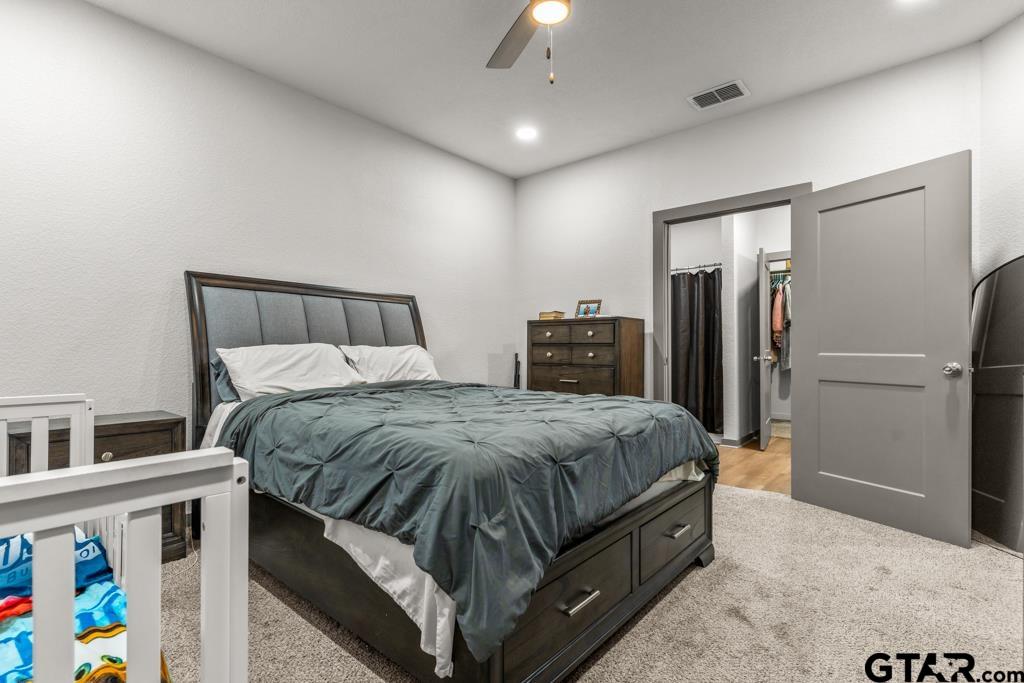 1919 West Jackson Street Tyler, TX 75701 - Photo 18 of 35 a spacious bedroom with a bed and a refrigerator