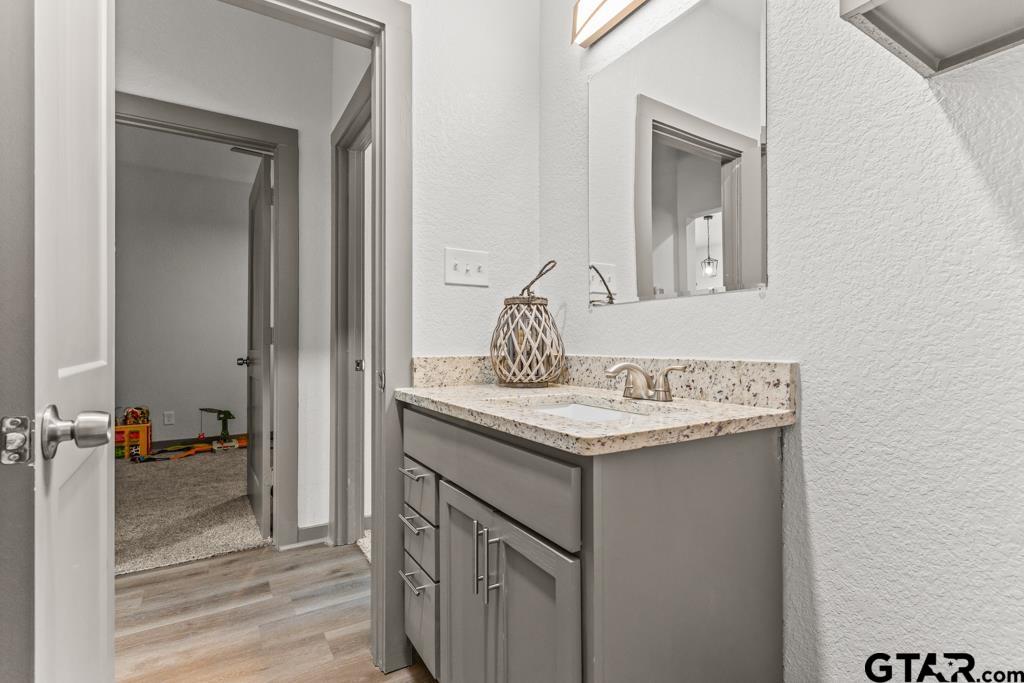 1919 West Jackson Street Tyler, TX 75701 - Photo 25 of 35 a bathroom with a granite countertop sink and a mirror