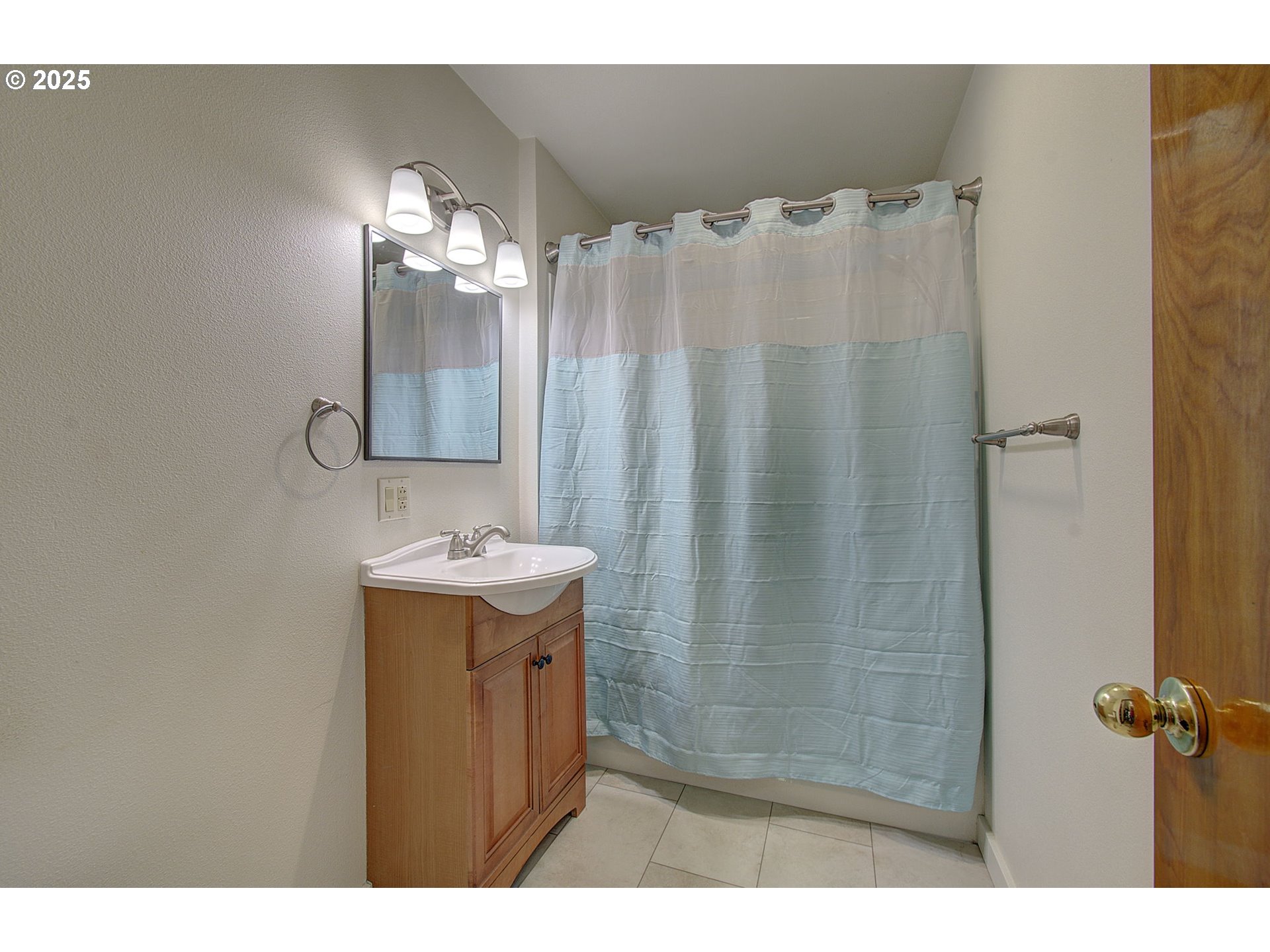 5911 Alki Road Vancouver, WA 98663 - Photo 12 of 29 a bathroom with a sink a mirror and a shower curtain