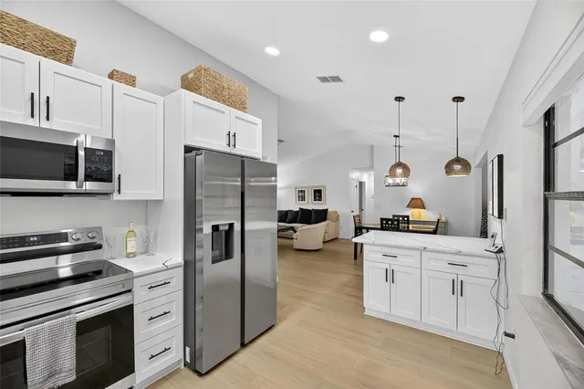 a kitchen with stainless steel appliances kitchen island granite countertop a refrigerator a stove and a sink