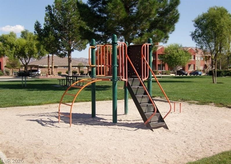 4730 East Craig Road, Unit 2102 Las Vegas, NV 89115 - Photo 2 of 13 A vibrant playground structure stands ready for recreation amidst green grass and distant buildings.