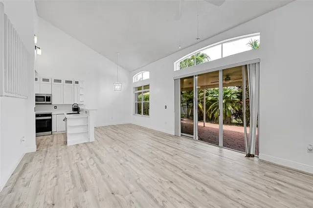 a view of kitchen with stainless steel appliances granite countertop a stove top oven a refrigerator a sink and a large window