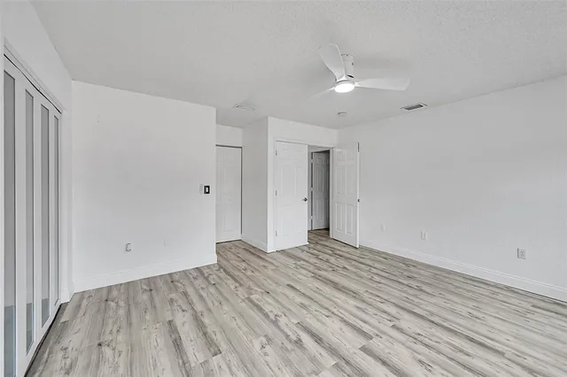 a view of an empty room with wooden floor