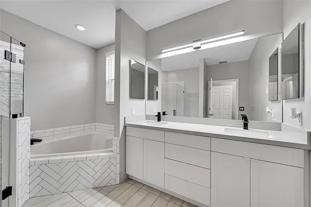 a bathroom with a tub sink and mirror