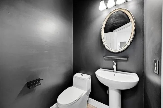 a bathroom with a sink a toilet and a mirror