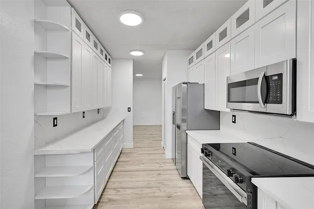 a kitchen with stainless steel appliances kitchen island granite countertop a refrigerator and a stove top oven