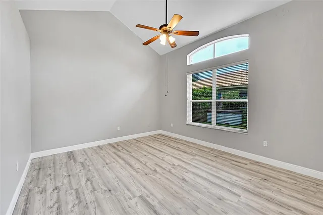 an empty room with a window and a ceiling fan