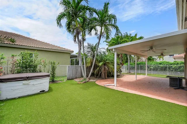 a view of a backyard with couches under an umbrella