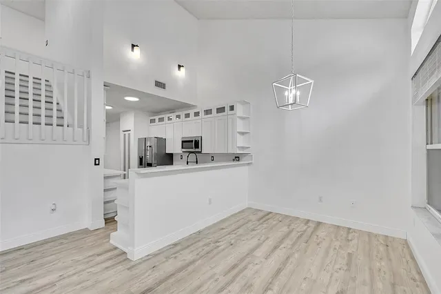 a kitchen with a refrigerator and white cabinets