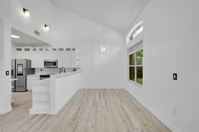 a kitchen with cabinets and wooden floor
