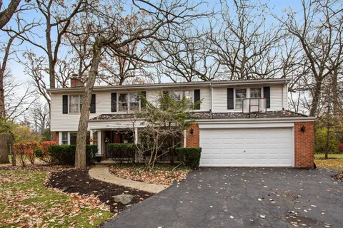 a view of a white house with large windows next to a road