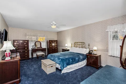 a spacious bedroom with a bed and a tv on table