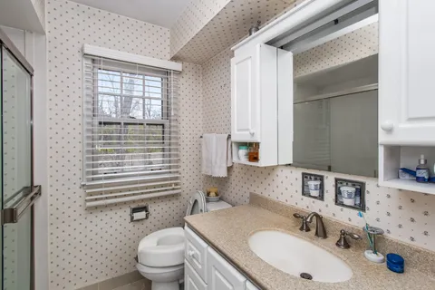 a bathroom with a sink toilet and mirror