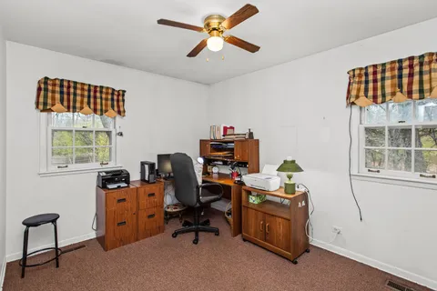 a view of a workspace with furniture and a window