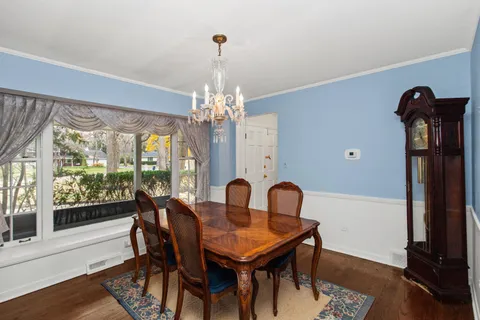 a view of a dining room with furniture wooden floor livingroom and chandelier