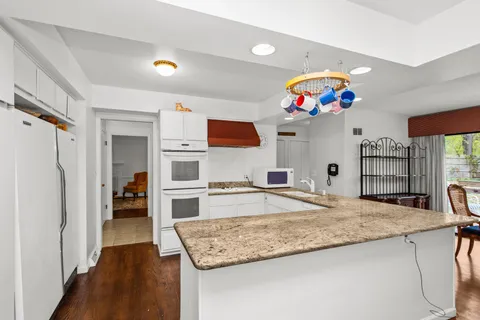 a kitchen with kitchen island granite countertop wooden cabinets and a refrigerator