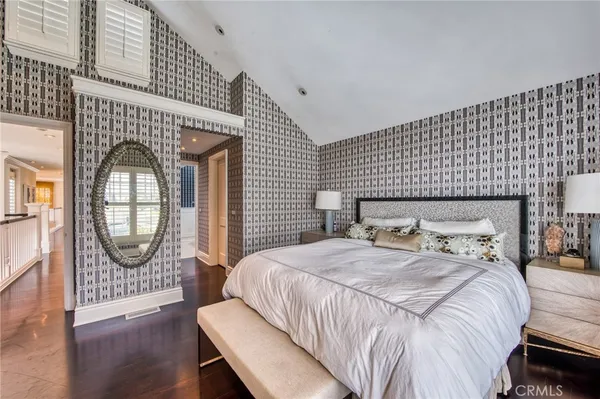 a bedroom with a bed a mirror with dresser and mirror