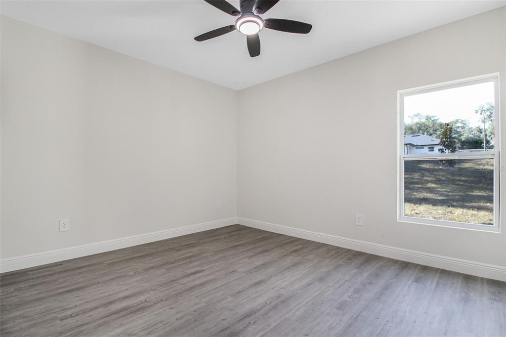 406 Ruby Avenue Deland, FL 32724 - Photo 7 of 23 a view of an empty room with wooden floor and window