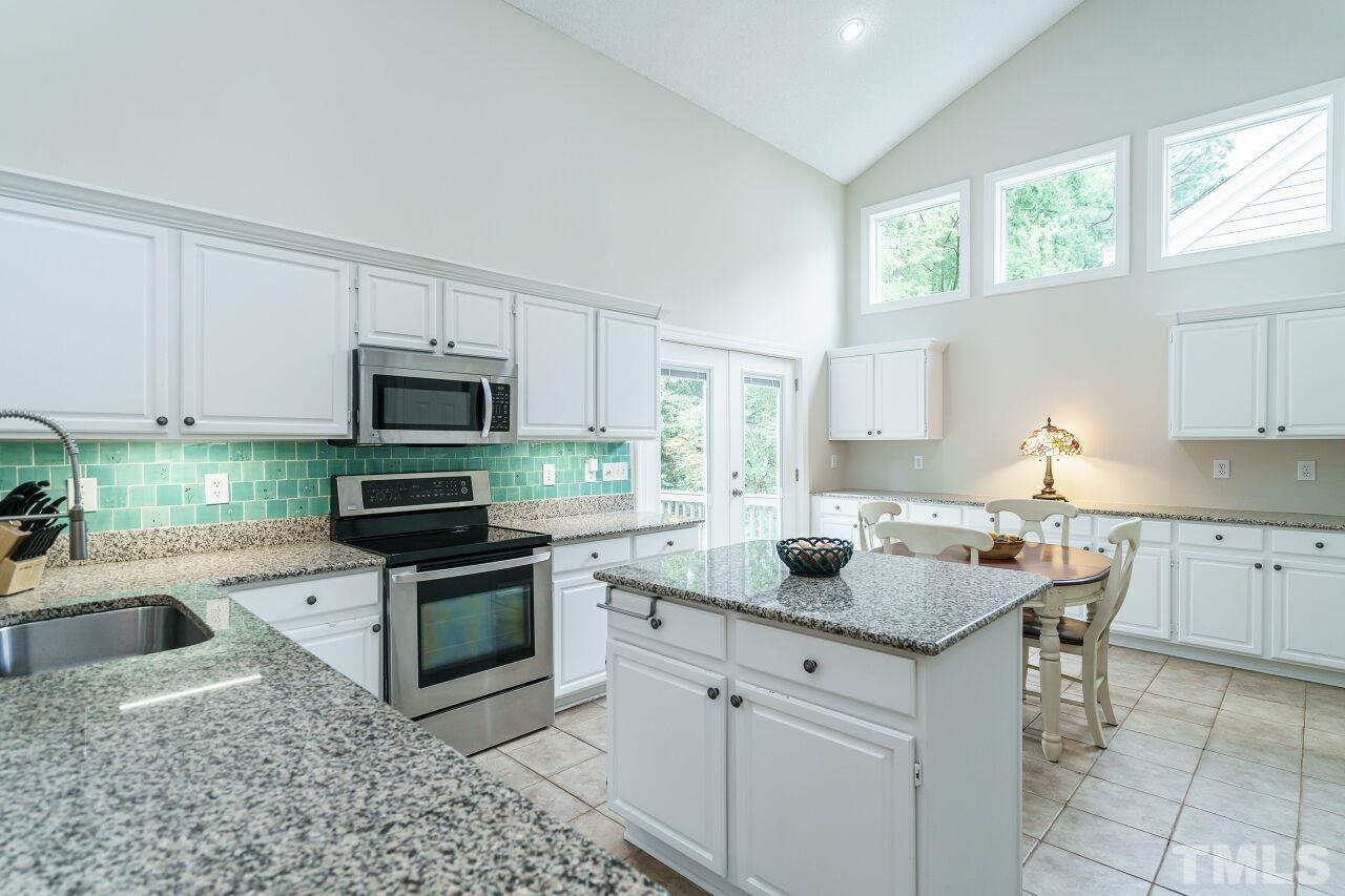 206 Firetree Lane Cary, NC 27513 - Photo 10 of 44 a kitchen with stainless steel appliances granite countertop a sink stove and microwave
