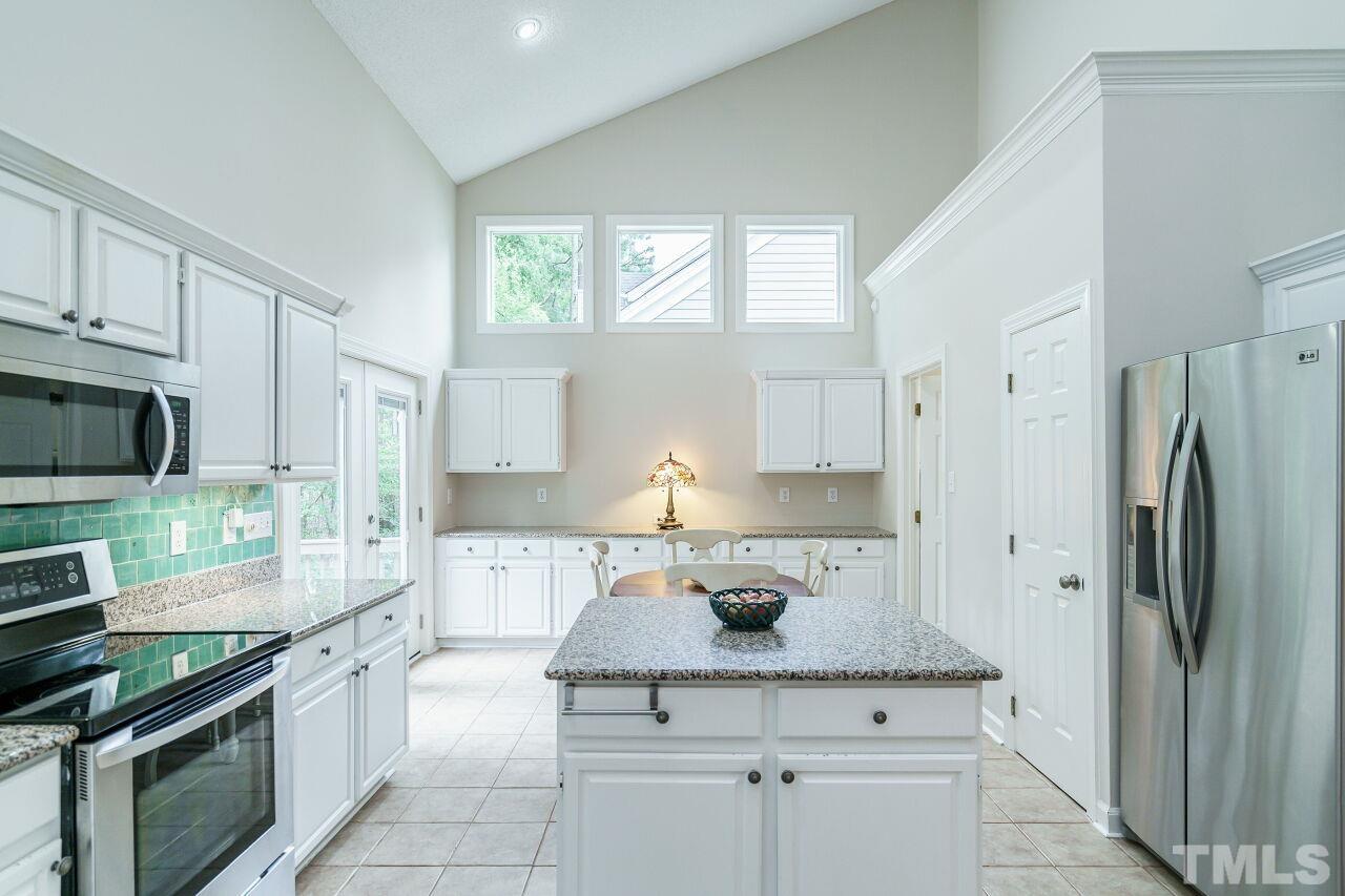 206 Firetree Lane Cary, NC 27513 - Photo 11 of 44 a kitchen with stainless steel appliances a sink stove and refrigerator
